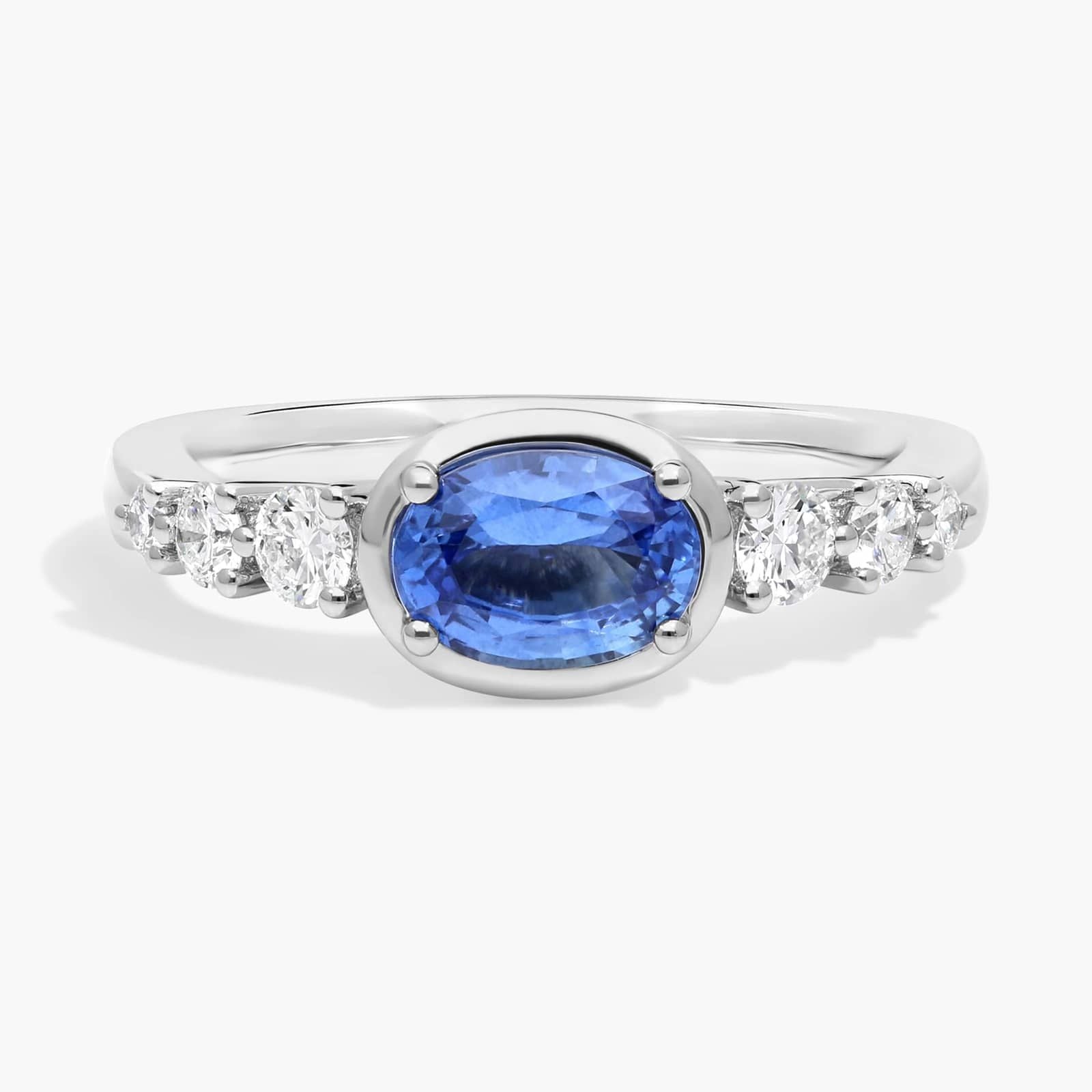 East-West Oval Cut Sapphire Ring With Half Bezel and Diamond Accent In White Gold / Yellow Gold