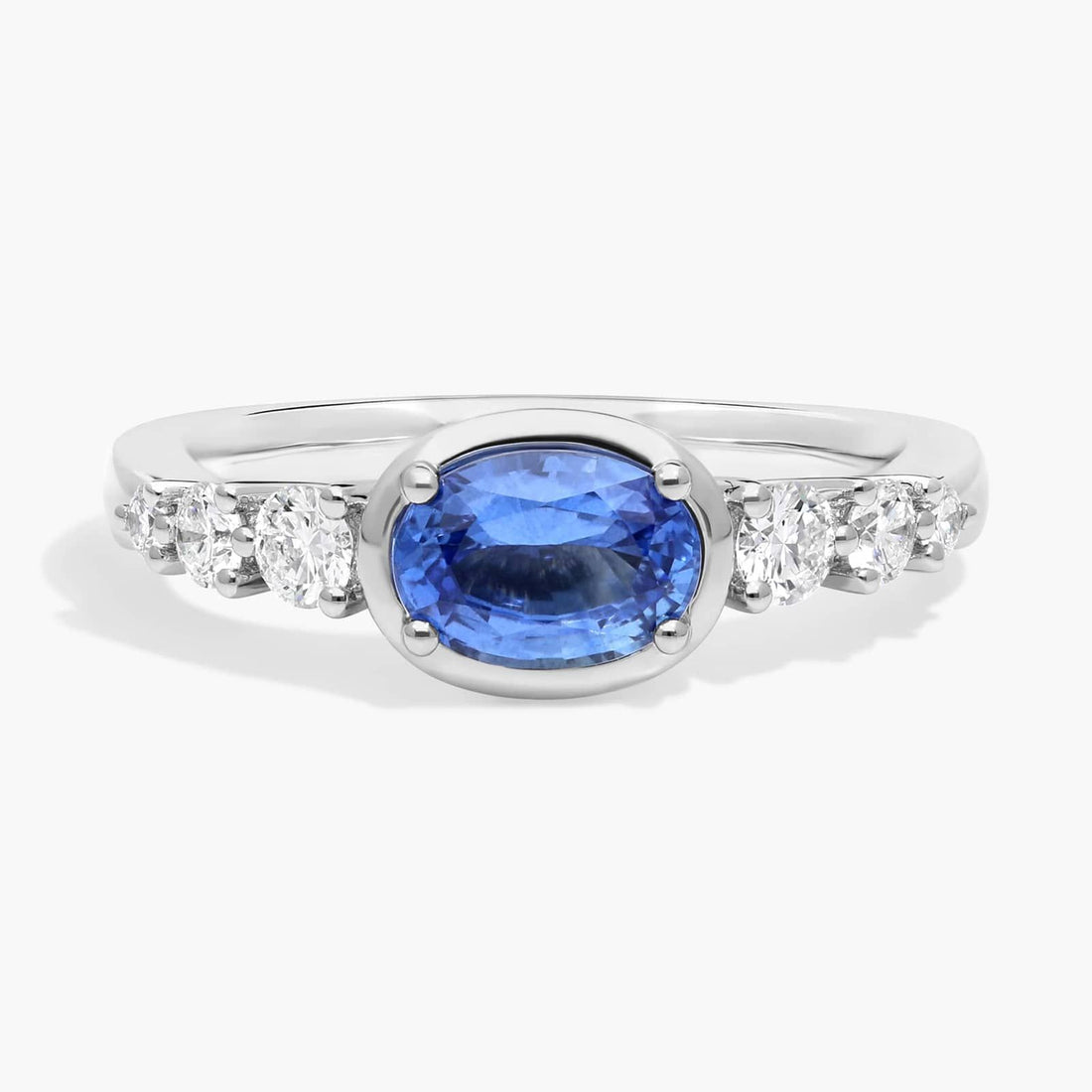 East-West Oval Cut Sapphire Ring With Half Bezel and Diamond Accent In White Gold / Yellow Gold